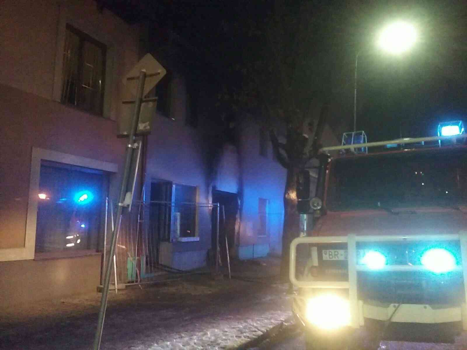 vstup do podchodu budovy v noci, hasičské auto